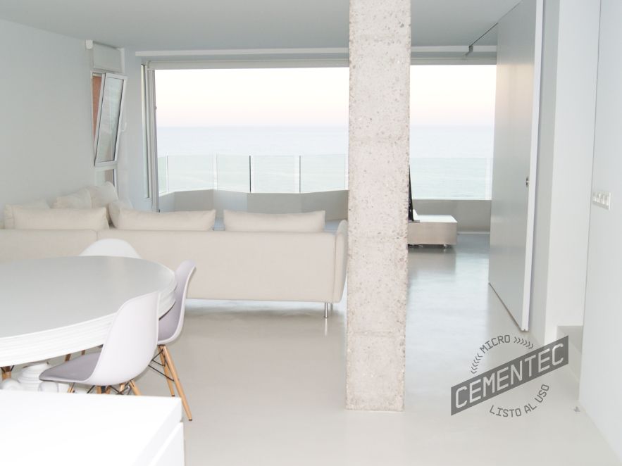 microcemento-blanco-en-sala-de-estar Living room with white Cementec microcement applied on the walls and floor, as well as white furniture.