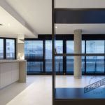 Coloured microcement flooring in an open room with large windows.
