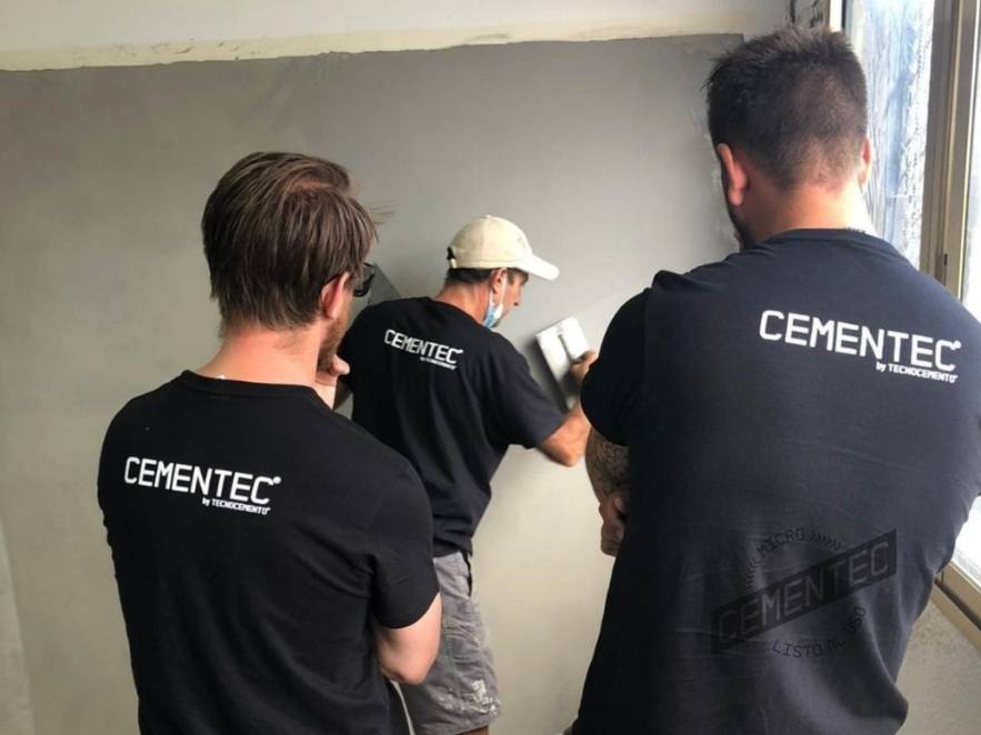 Alumnos del curso de aplicadores de microcemento por parte de Cementec observando un ejemplo de aplicación por un instructor.